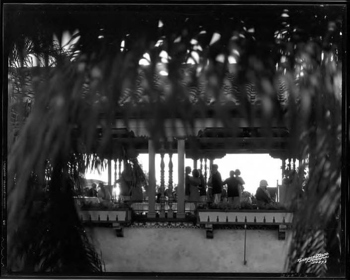丛林乡村俱乐部酒店 patrons silhouetted during tea dance, framed by exterior tropical vegetation, 1932 – Burgert Brothers